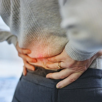 A woman holding her lower back in pain